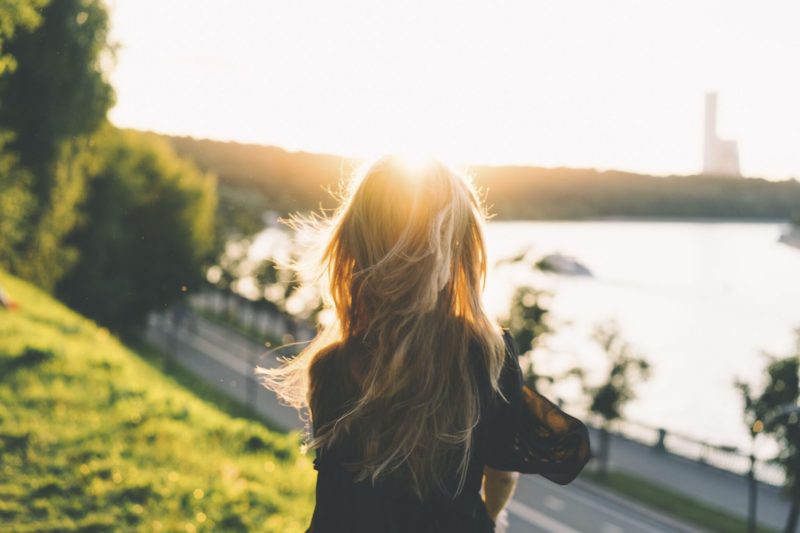 view of woman looking down on beach ample background