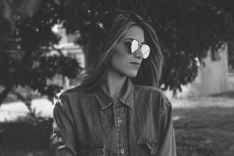 brunette with aviator glasses looking right
