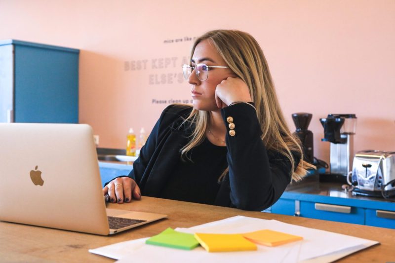 younf woman at table with Apple laptop